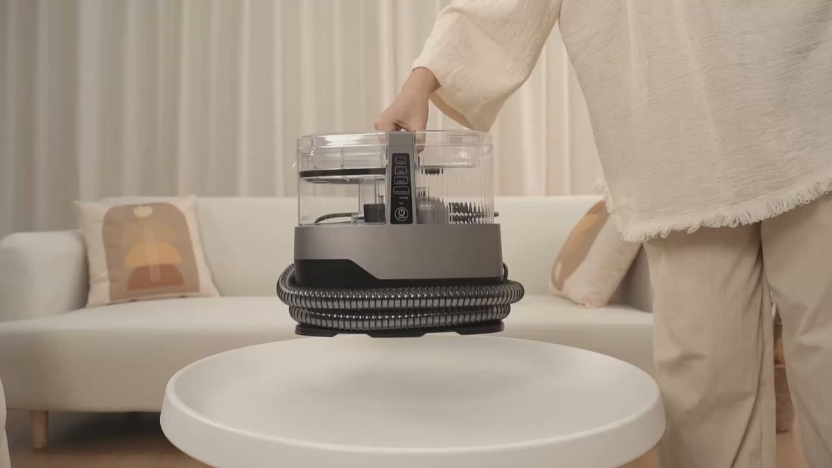 Charger la vidéo : Femme soulevant la shampouineuse Steam Force par sa poignée dans un salon